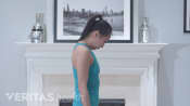 Profile view of woman doing the flexion neck stretch