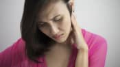 Woman holding the side of her head and neck in pain