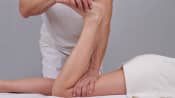 Chiropractor manipulating a patient&#039;s lower leg.