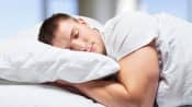 Young man sleeping in a bed with a pillow