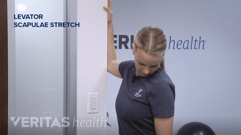 Therapist showing levator scapulae stretch.
