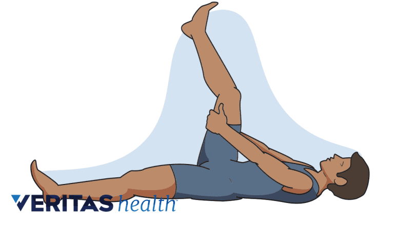 Man lying on back doing hamstring stretch.